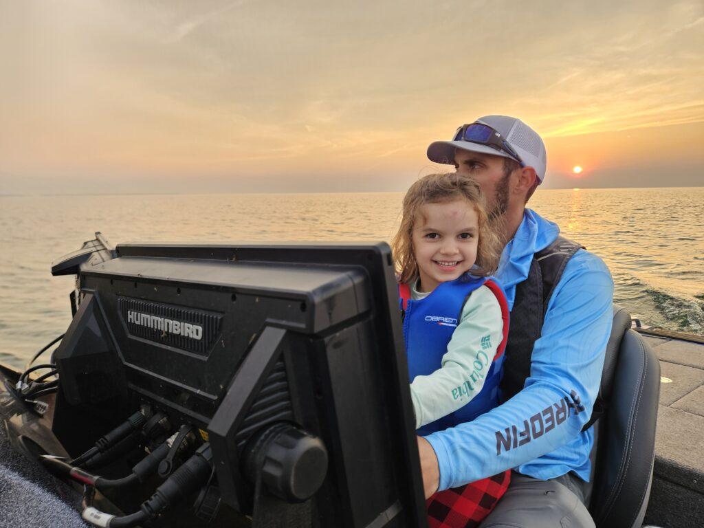 Captain Destin DeMarion driving on Lake Erie with his daughter