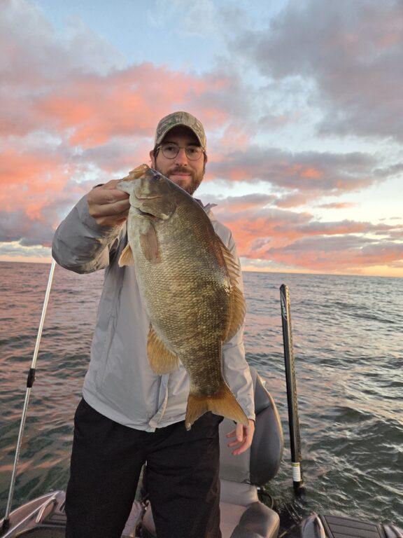 Angler holding a healthy October Lake Erie smallmouth bass