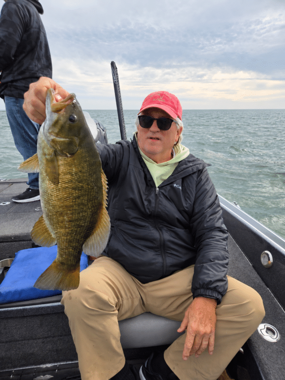 Angler holding a healthy October Lake Erie smallmouth bass